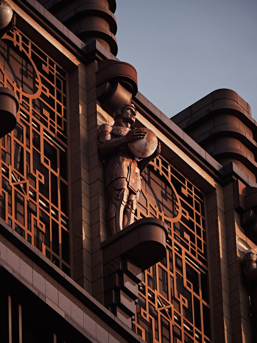 Detail of an art deco facade with a carved stone figure.